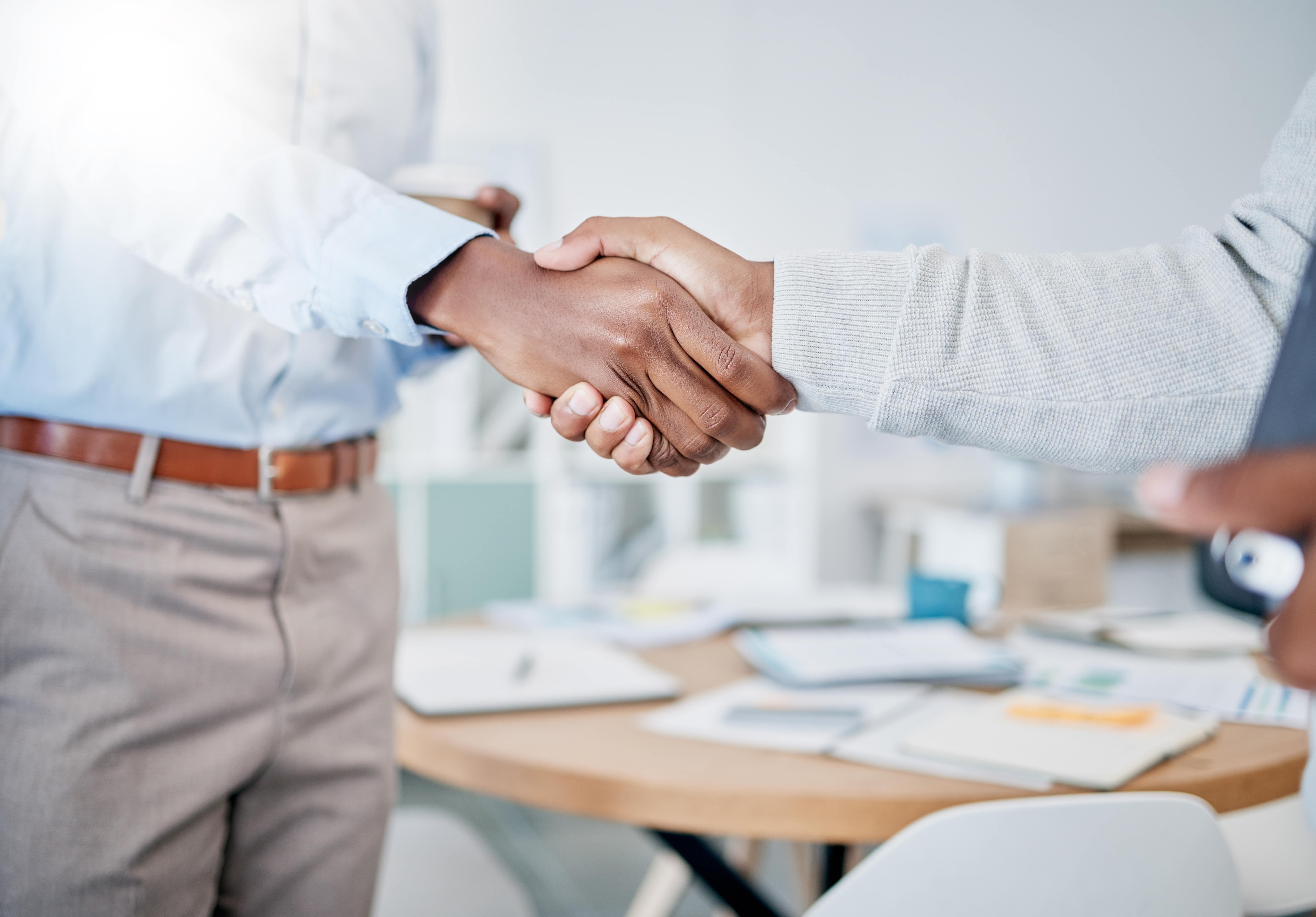 business partner shaking hands over mortgage loan servicing